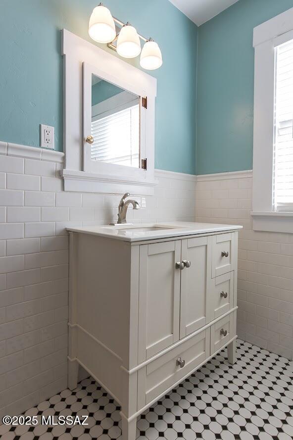 bathroom with vanity and tile walls