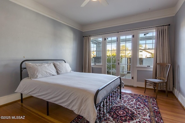 bedroom featuring crown molding, hardwood / wood-style flooring, ceiling fan, access to exterior, and french doors