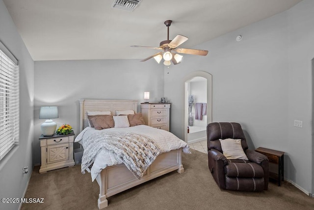 carpeted bedroom with connected bathroom, vaulted ceiling, and ceiling fan