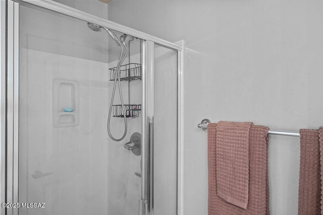 bathroom with a shower with door