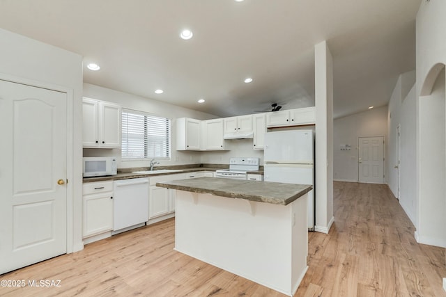 kitchen with white cabinetry, a center island, sink, and white appliances