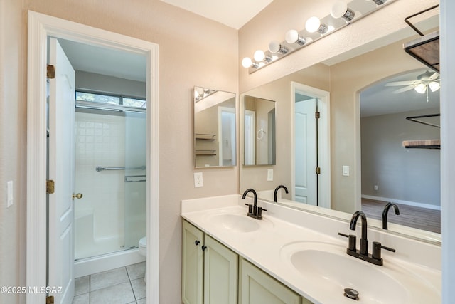 bathroom featuring ceiling fan, tile patterned flooring, vanity, a shower with shower door, and toilet