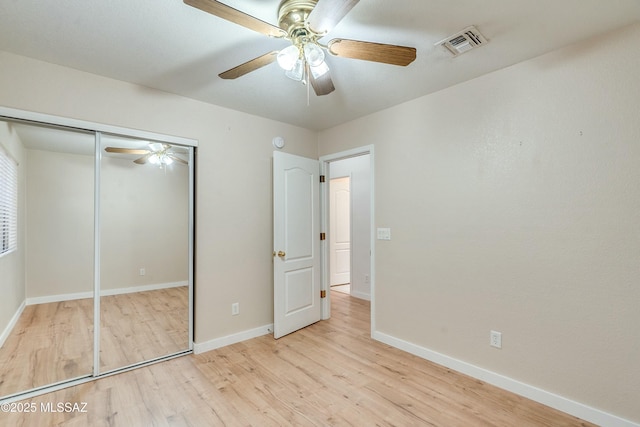 unfurnished bedroom featuring ceiling fan, light hardwood / wood-style floors, and a closet