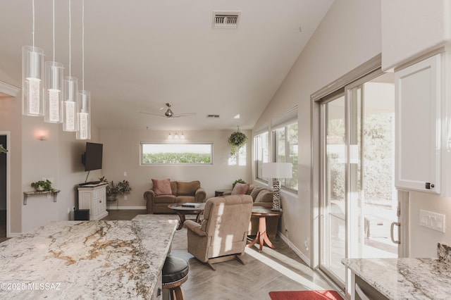 living room featuring ceiling fan, lofted ceiling, plenty of natural light, and light parquet floors