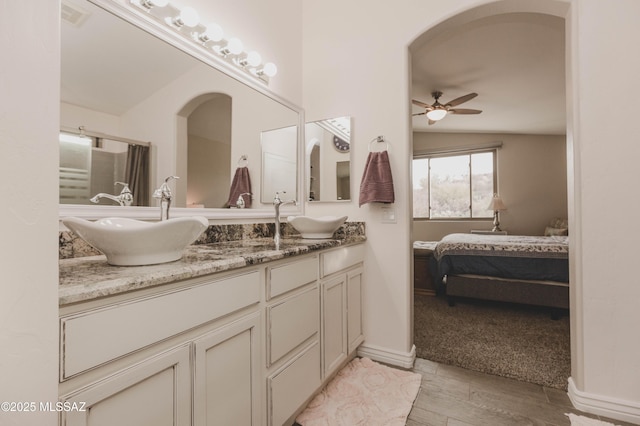 bathroom featuring vanity, wood-type flooring, lofted ceiling, and ceiling fan