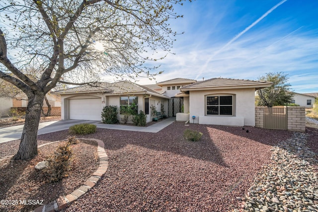 view of front of home with driveway, an attached garage, and stucco siding