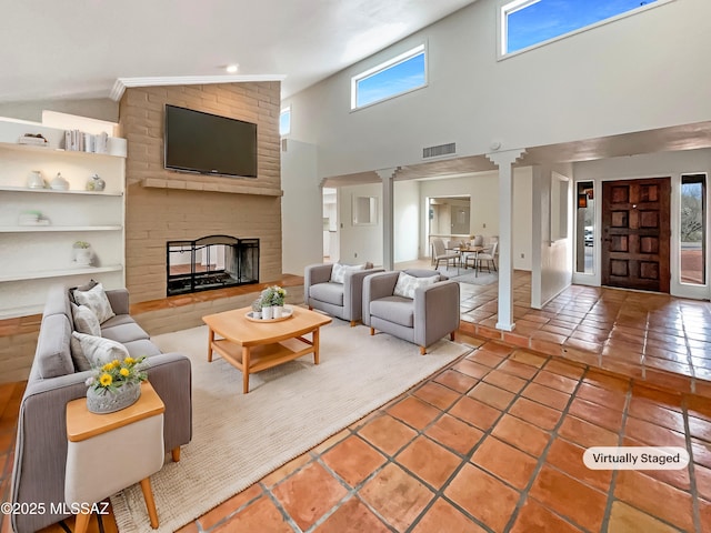 living room featuring lofted ceiling, tile patterned flooring, decorative columns, and a brick fireplace