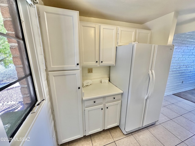 kitchen featuring light tile patterned floors, white cabinetry, light countertops, and freestanding refrigerator