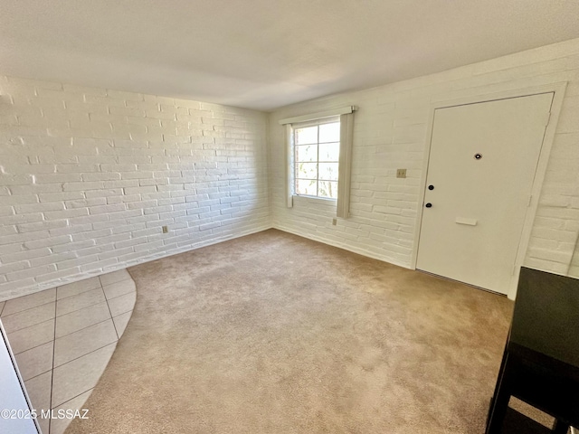 interior space featuring brick wall and carpet floors