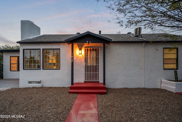 view of front of house with roof with shingles and stucco siding