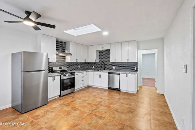 kitchen with tasteful backsplash, appliances with stainless steel finishes, a skylight, and a ceiling fan