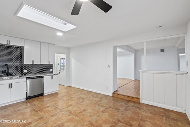 kitchen featuring sink, decorative backsplash, stainless steel dishwasher, and white cabinets