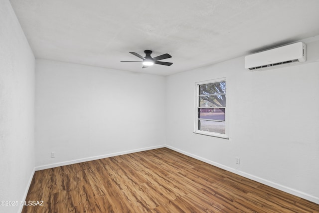 spare room featuring wood-type flooring, an AC wall unit, and ceiling fan