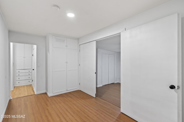 unfurnished bedroom with a closet and light wood-type flooring