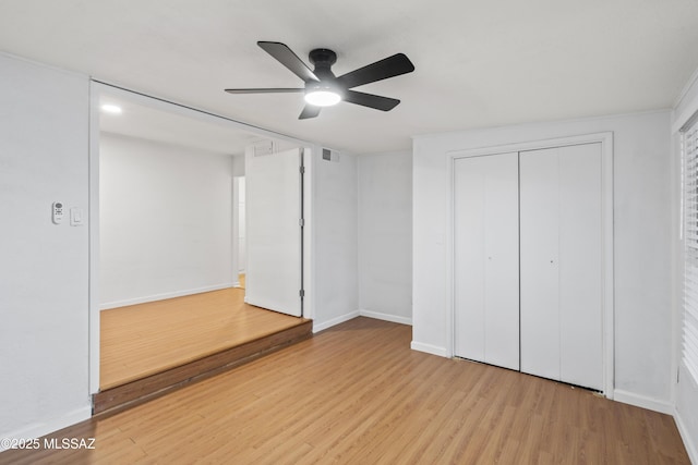 unfurnished bedroom with a closet, ceiling fan, baseboards, and wood finished floors