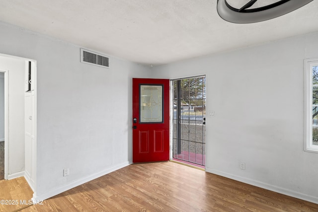 spare room with visible vents, light wood-style flooring, and baseboards