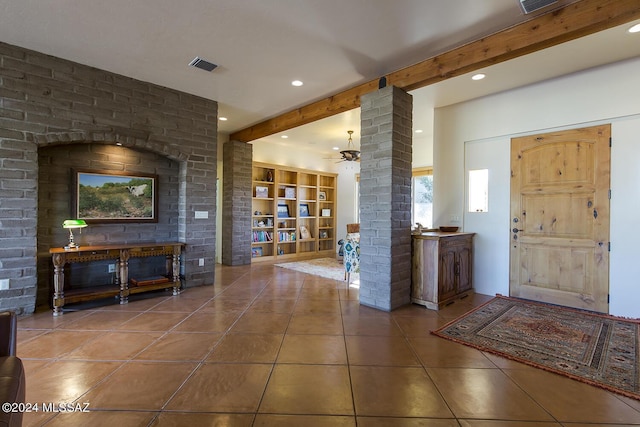 entryway featuring beam ceiling, tile patterned flooring, and ornate columns