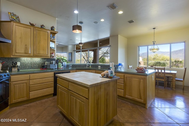 kitchen with dishwasher, decorative backsplash, stove, a center island, and a mountain view