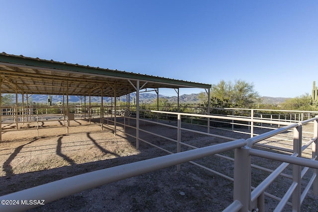 view of stable featuring a mountain view and a rural view