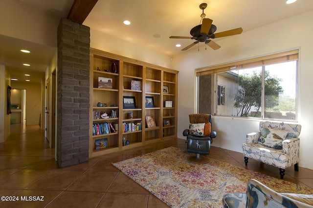 sitting room with ceiling fan and dark tile patterned floors