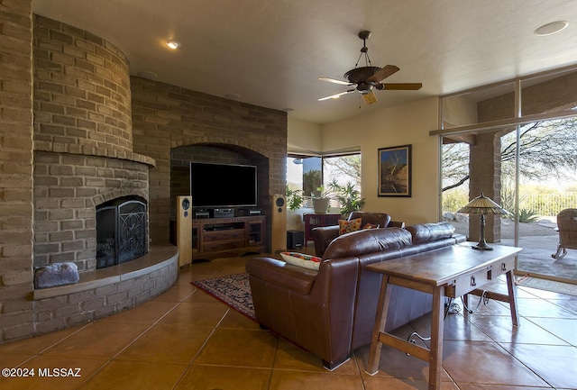 tiled living room with a fireplace and ceiling fan