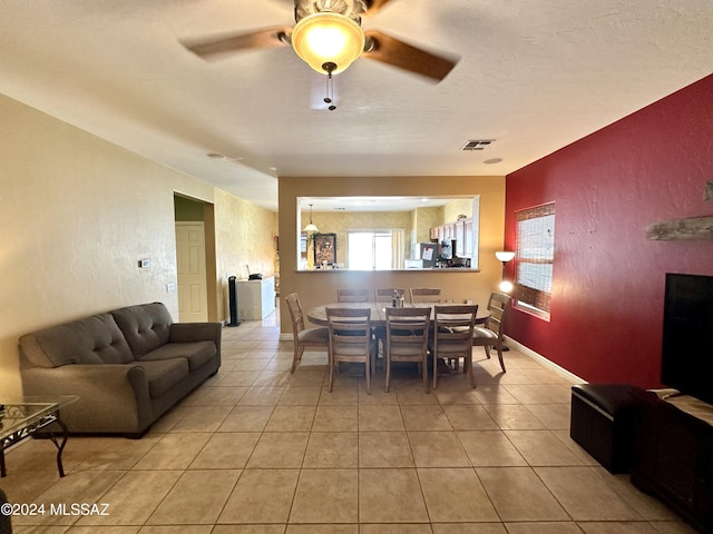 tiled dining area featuring a textured ceiling and ceiling fan