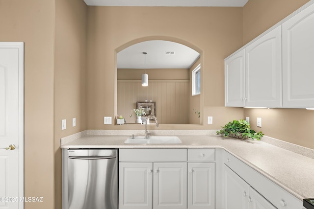 kitchen featuring stainless steel dishwasher, sink, hanging light fixtures, and white cabinets