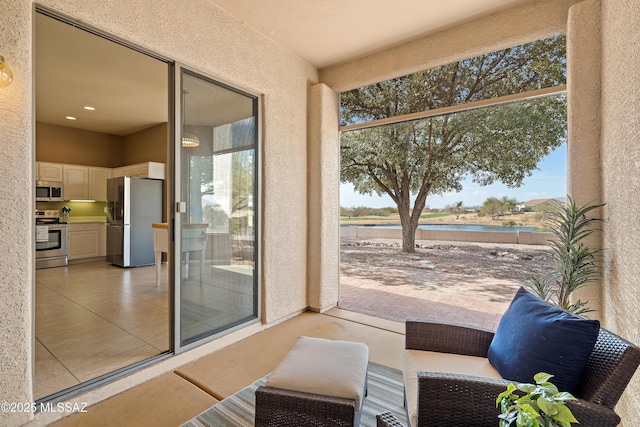 interior space with a water view and light tile patterned floors