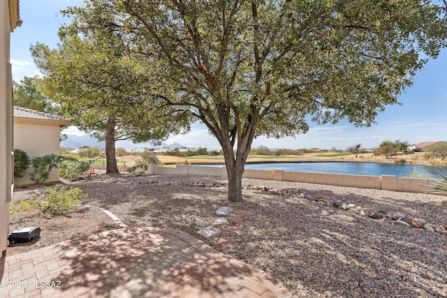 view of yard featuring a water view and a patio area