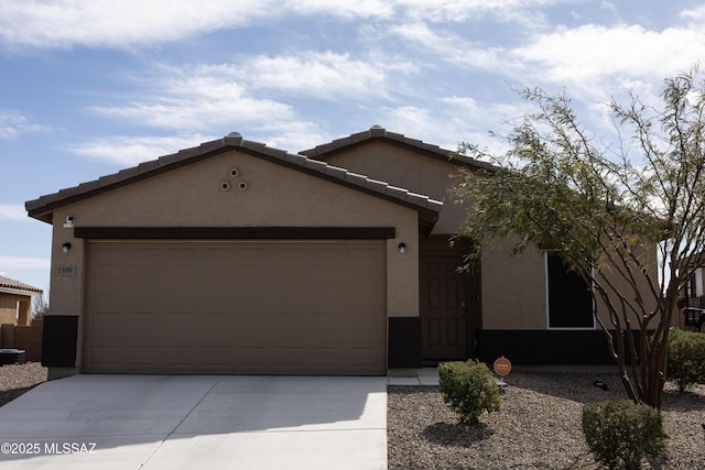 ranch-style home with driveway, an attached garage, a tiled roof, and stucco siding