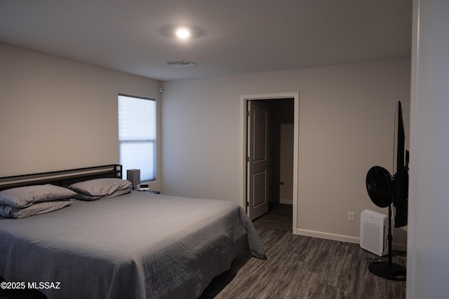 bedroom with dark wood-type flooring, visible vents, and baseboards