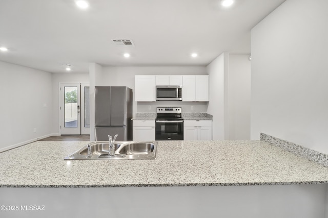 1599 W Cottonwood Bluffs Dr, Benson, AZ 85602 - kitchen with appliances with stainless steel finishes, a sink, recessed lighting, white cabinets, and a peninsula