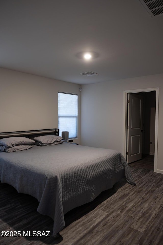 bedroom featuring wood finished floors and visible vents