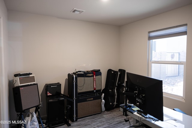 misc room with a healthy amount of sunlight, visible vents, and wood finished floors
