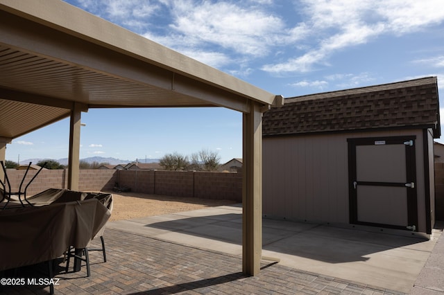 view of patio / terrace featuring an outbuilding, a fenced backyard, grilling area, and a storage shed