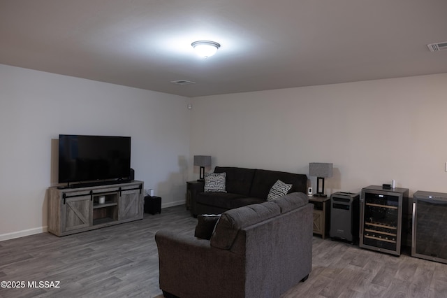 living room with wine cooler, wood finished floors, and visible vents