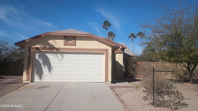 garage with driveway and fence