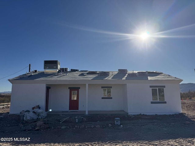 view of front of property featuring central AC and stucco siding