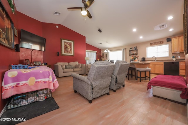 living room with lofted ceiling, sink, ceiling fan with notable chandelier, and light wood-type flooring