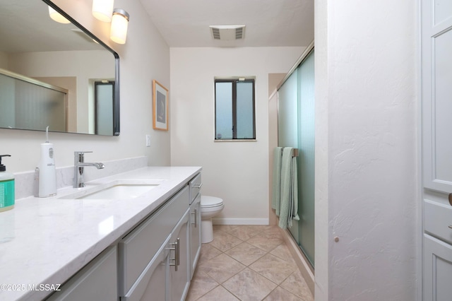 bathroom with vanity, tile patterned flooring, toilet, and walk in shower