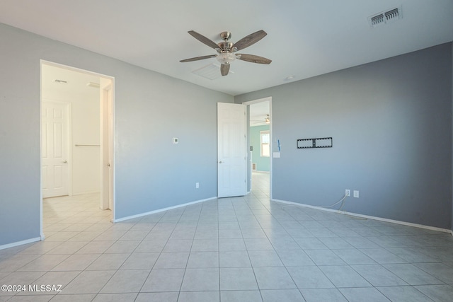 tiled empty room featuring ceiling fan