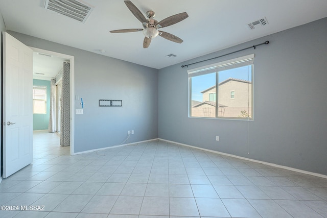 tiled spare room featuring ceiling fan