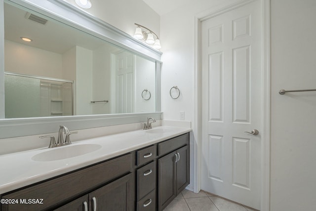 bathroom featuring tile patterned flooring, vanity, and walk in shower