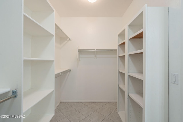 walk in closet with light tile patterned floors