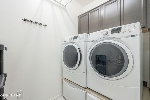 laundry room with cabinets and washer and clothes dryer