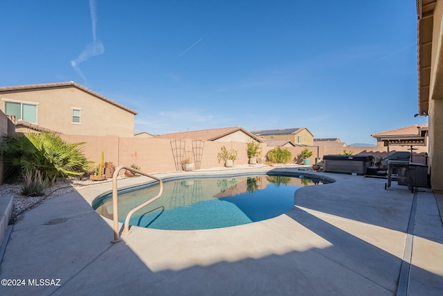 view of pool with a hot tub and a patio area