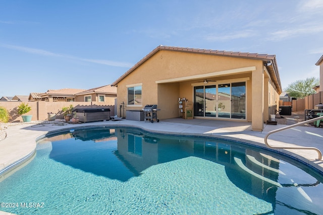 view of pool with ceiling fan, a grill, a hot tub, and a patio area