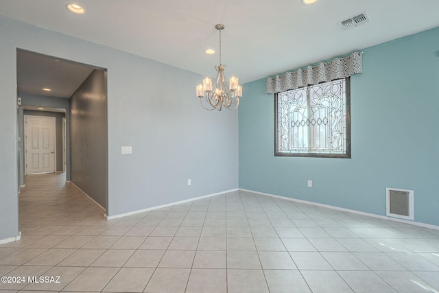 empty room featuring a notable chandelier and light tile patterned floors