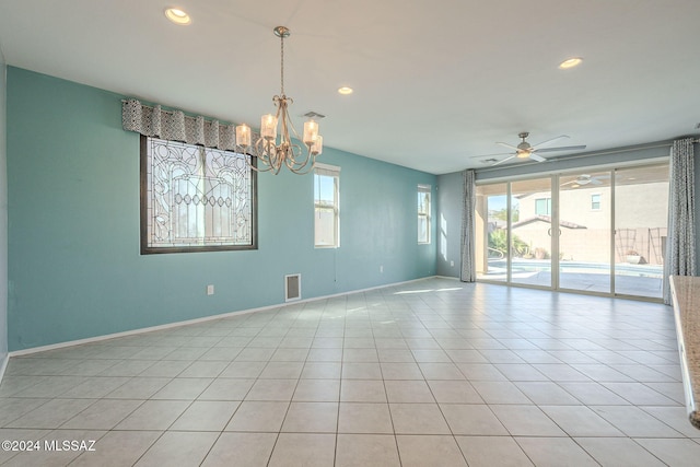 unfurnished room with light tile patterned flooring and ceiling fan with notable chandelier