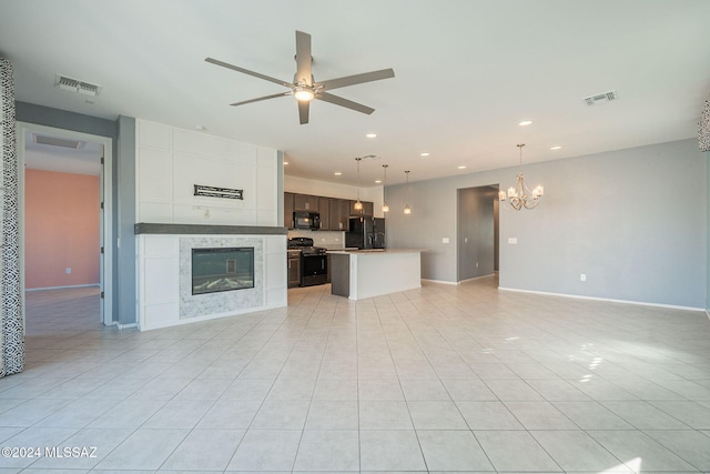 unfurnished living room featuring light tile patterned flooring and ceiling fan with notable chandelier